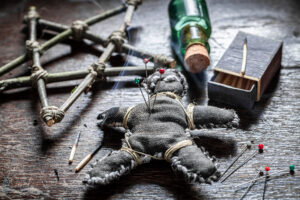 voodoo spell altar with voodoo doll pierced by a needle