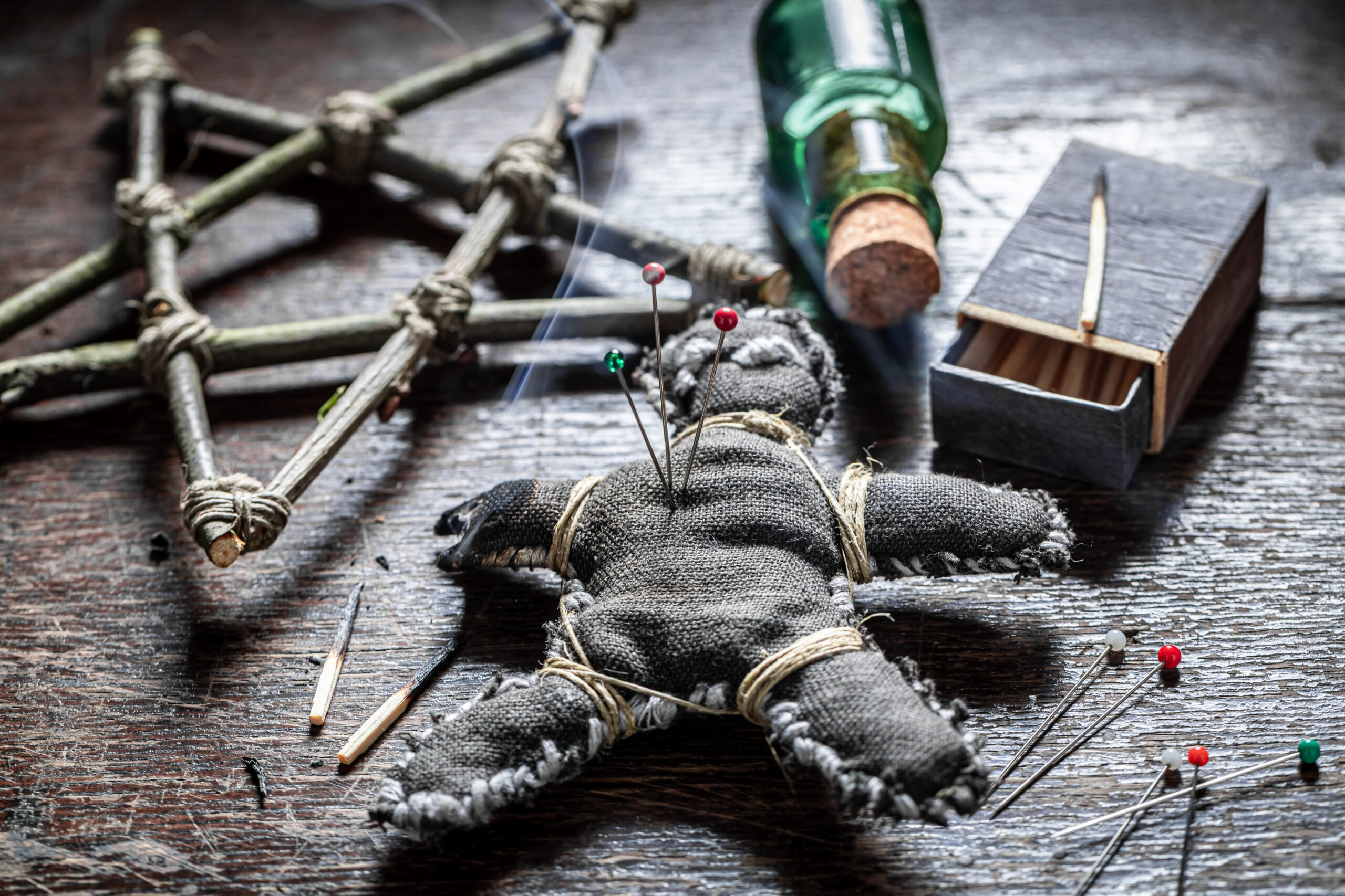 voodoo spell altar with voodoo doll pierced by a needle